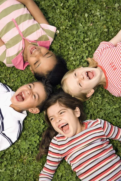 Children Lying in Clover Screaming With Heads Together — Stock Photo, Image