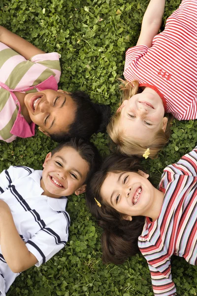 Children Lying in Clover With Heads Together — Stock Photo, Image