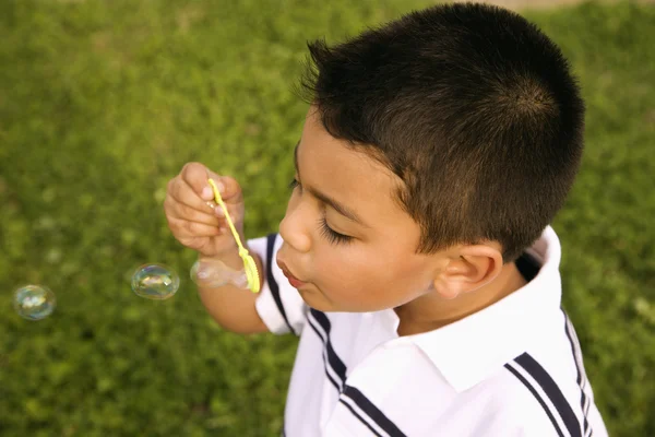 Giovane ragazzo soffiando bolle — Foto Stock