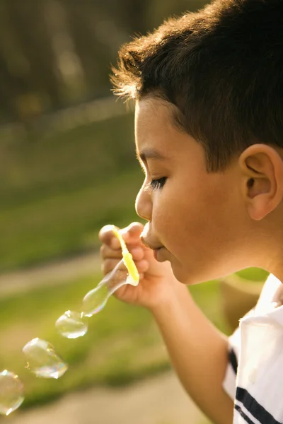 Jeune garçon soufflant des bulles — Photo