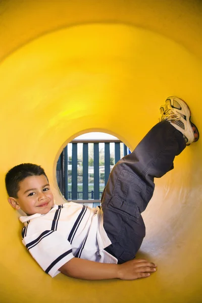 Menino jovem deitado no tubo de rastreamento — Fotografia de Stock