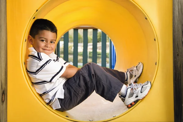 Giovane ragazzo sdraiato in tubo strisciante — Foto Stock