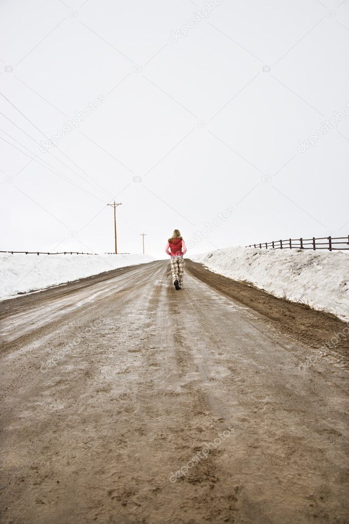 Woman walking down road.