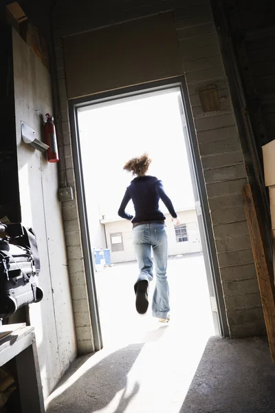 Woman running out door. — Stock Photo, Image