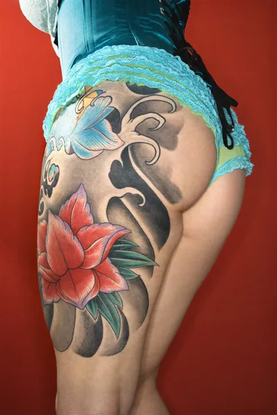 Tetovált womans láb és derriere — Stock Fotó
