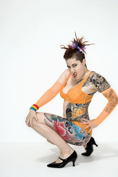 Mulher tatuada agachada — Fotografia de Stock