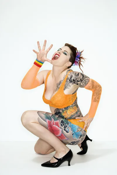 Татуированная женщина на корточках — стоковое фото