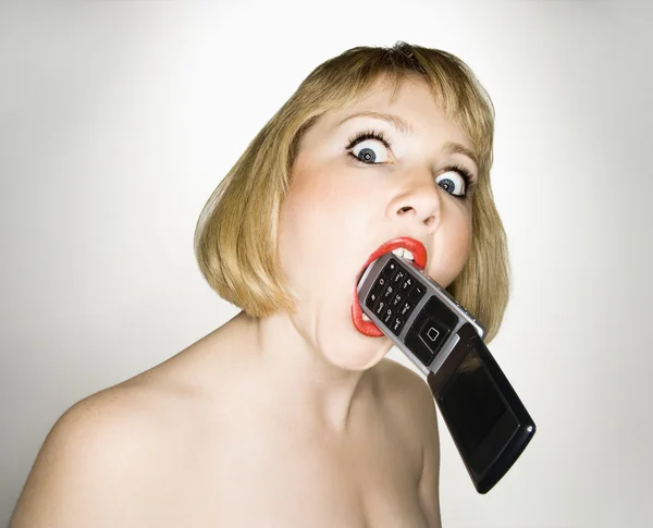 Crazy woman biting phone. — Stock Photo, Image