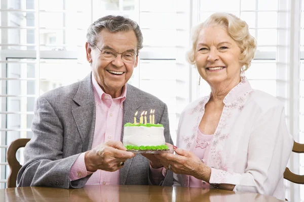 Mature couple with cake. — Stock Photo, Image