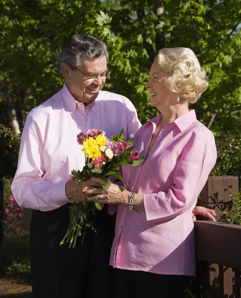 Зрелый мужчина преподносит цветы . — стоковое фото