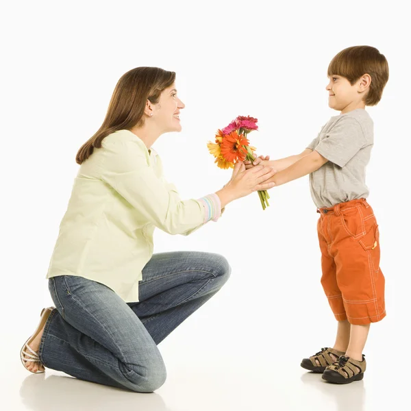 Pojke ger mamma blommor. — Stockfoto
