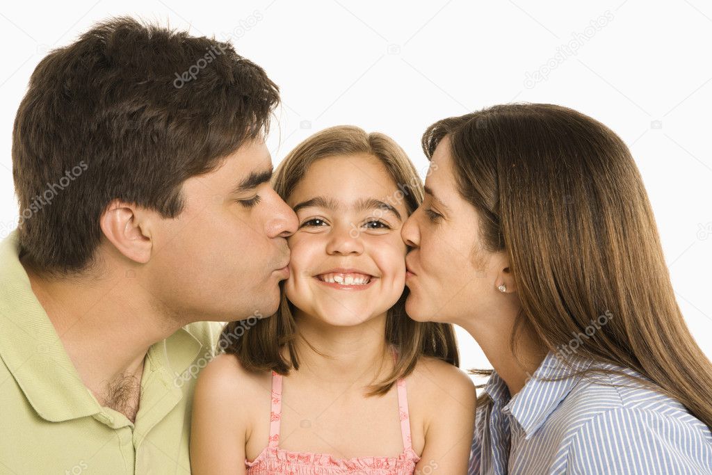 Parents kissing daughter.