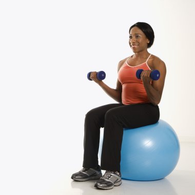 Woman lifting weights on ball. clipart