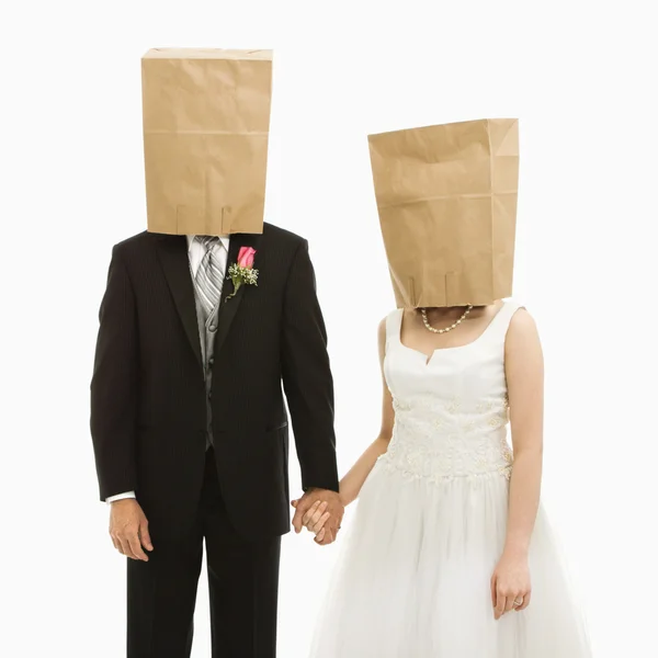 Wedding couple with bags over heads. — Stock Photo, Image