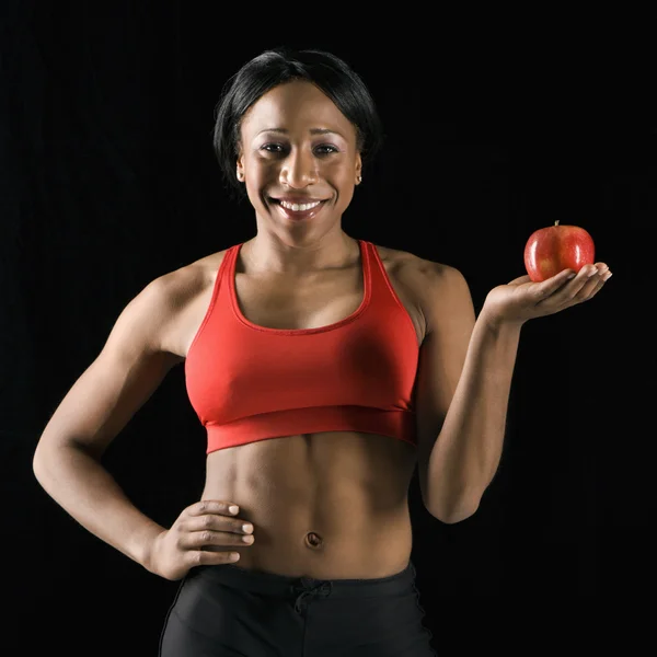 Atletische vrouw bedrijf apple. — Stockfoto