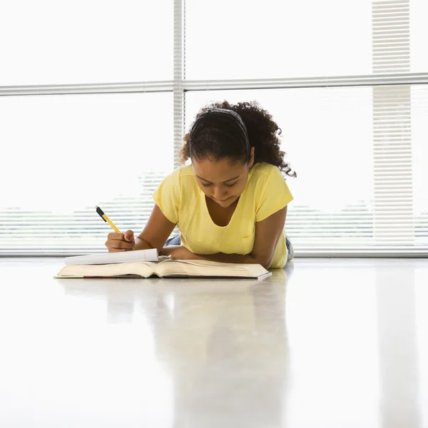 Flickan gör skolarbete. — Stockfoto