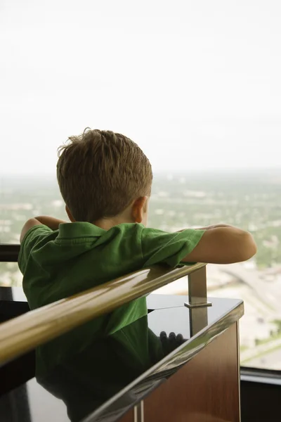 Boy leaning on railing. — Stockfoto