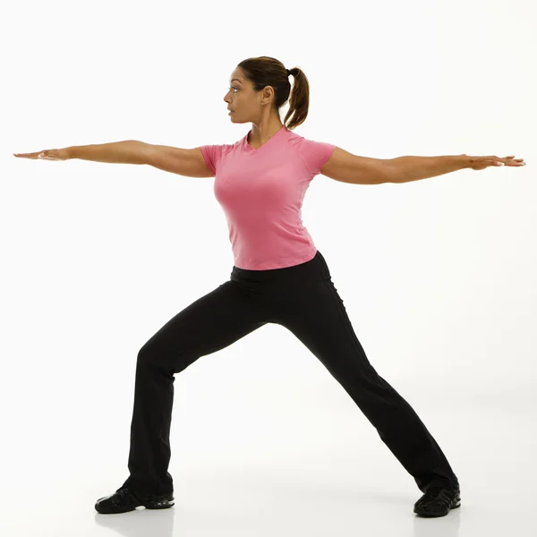 Kvinna utövar yoga. Stockbild