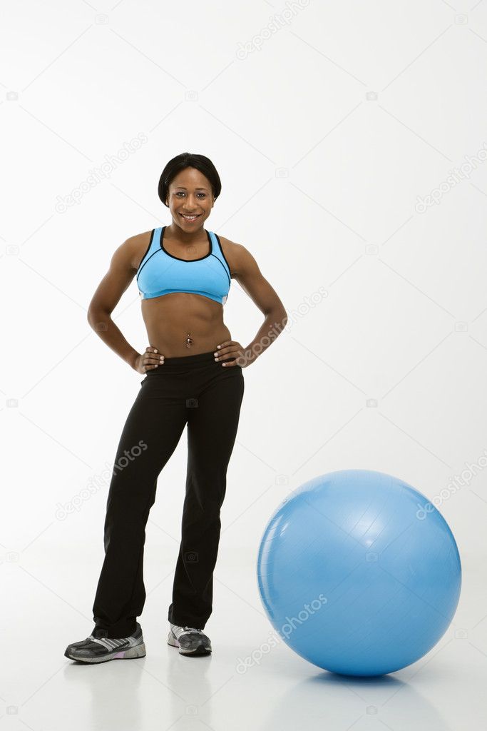 Woman standing with exercise ball.
