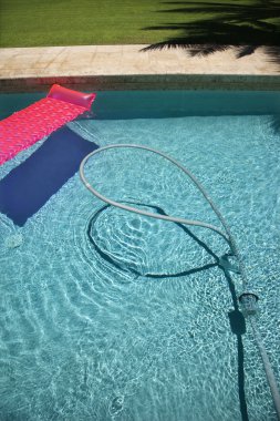 Float and vacuum in pool. clipart