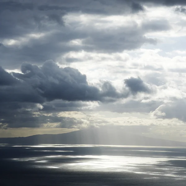 島と雲の中の太陽. — ストック写真
