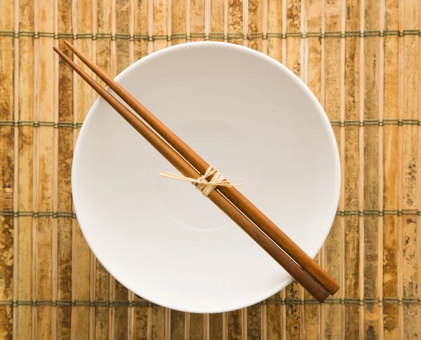 Eetstokjes op een lege bowl — Stockfoto