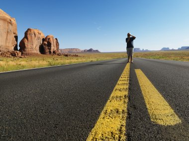 Boy in desert road. clipart