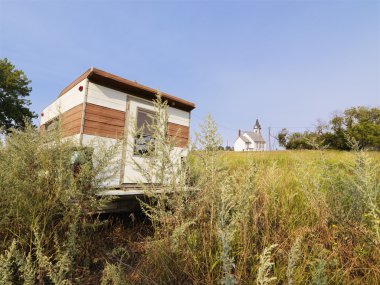 Camper and church in field. clipart