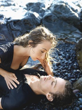 Attractive Young Couple Lying on Rocks clipart