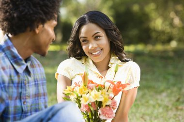 Man giving woman flowers. clipart