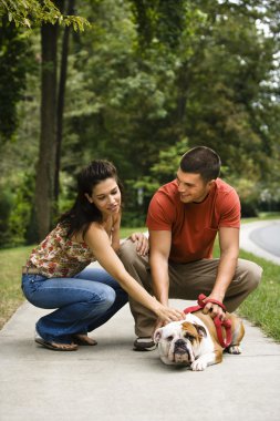 Couple petting dog. clipart