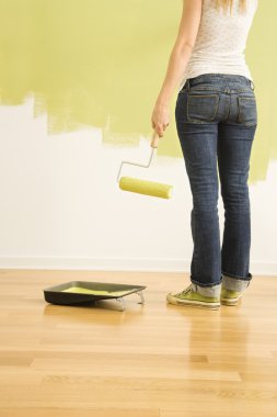 Woman painting wall. clipart