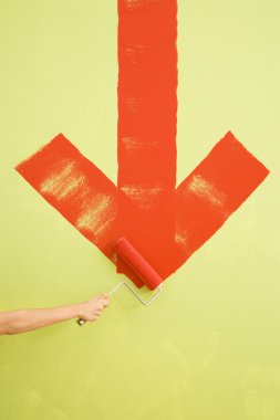 Woman painting arrow on wall. clipart