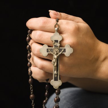 Woman holding rosary. clipart