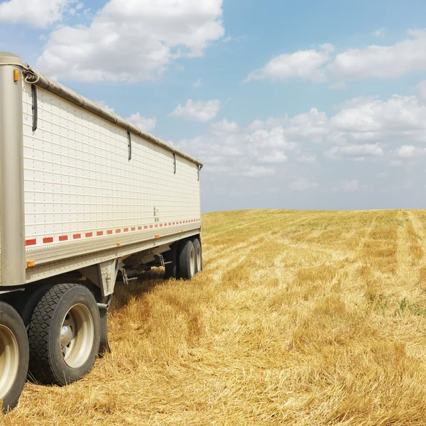 Trekker trailer vrachtwagen in veld. — Stockfoto