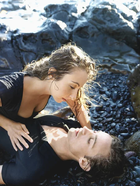 Attrayant jeune couple allongé sur des rochers — Photo