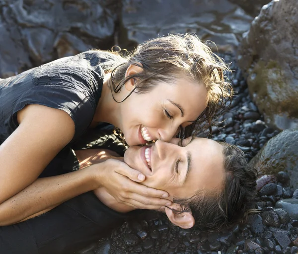 Casal jovem atraente em rochas sorrindo — Fotografia de Stock