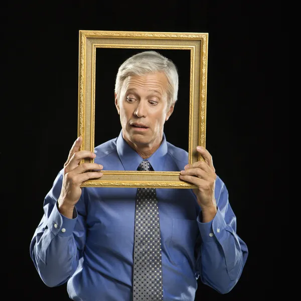 Hombre sosteniendo marco de imagen . —  Fotos de Stock
