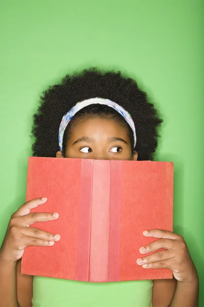 Mädchen blickt über Buch. — Stockfoto