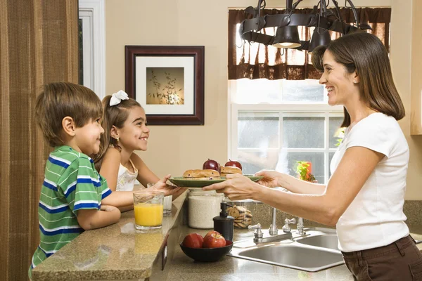 Mutter gibt Kindern Frühstück. — Stockfoto