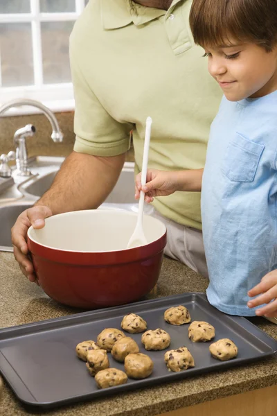 Батько і син робить печиво. — стокове фото