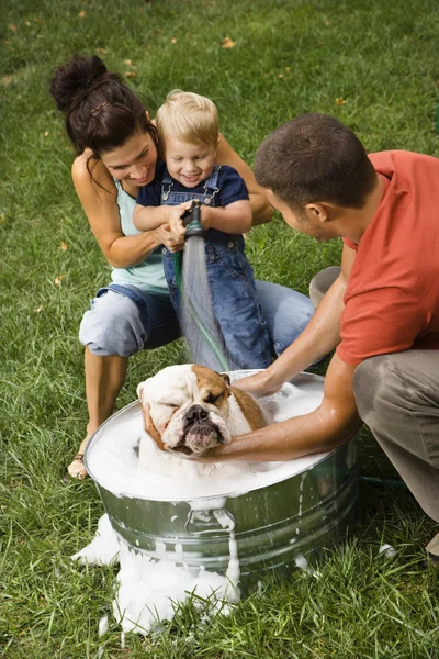 Familie gibt Hund ein Bad. — Stockfoto
