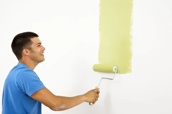 Smiling man painting. — Stock Photo, Image