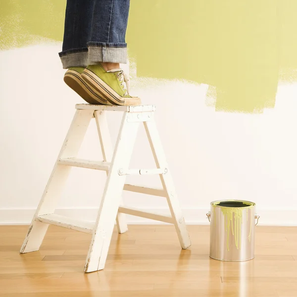 Woman on ladder painting. — Stock Photo, Image