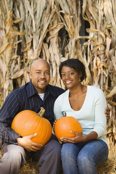 Couple holding pumpkins. — Stock Photo, Image