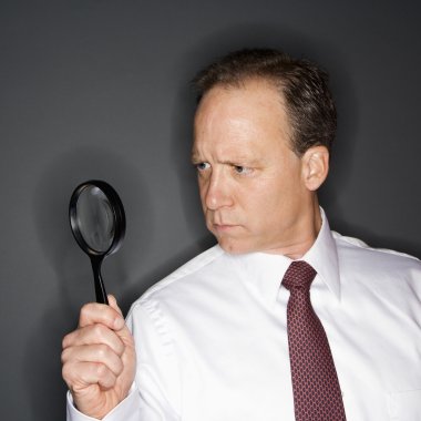 Businessman with magnifying glass clipart