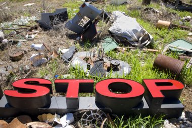 Letters spelling STOP in trashy junkyard. clipart