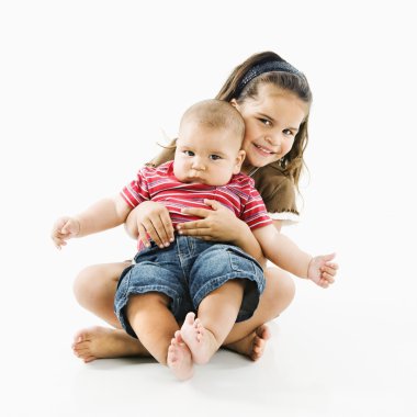 Hispanic child holding baby. clipart