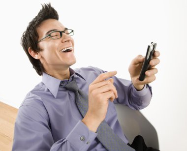 Man laughing at text message. clipart