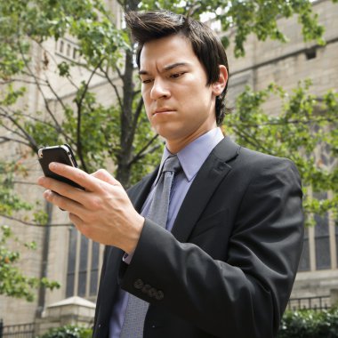 Businessman looking at cell phone. clipart